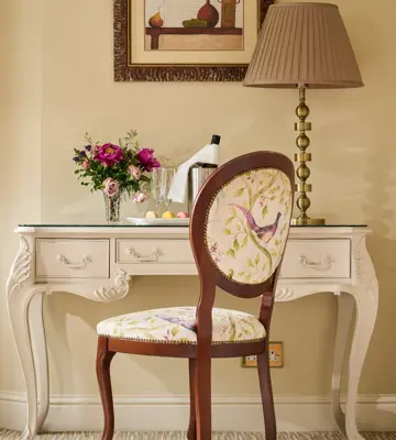 French-style dressing table set features a cream-colored console desk with delicate floral upholstery on the chair