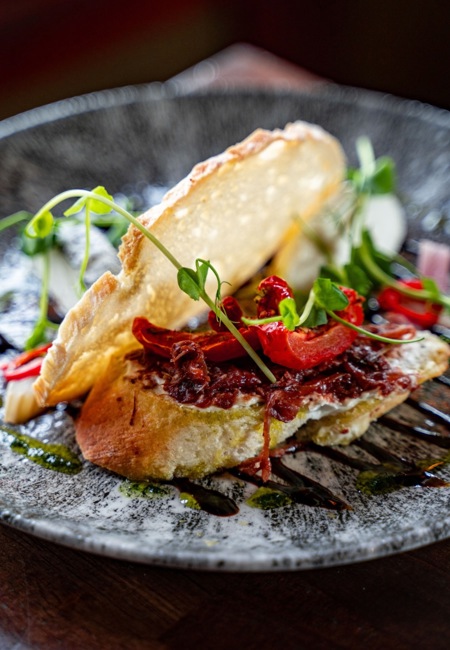  open-faced grilled fish sandwich features seasoned fish topped with sun-dried tomatoes, fresh microgreens, and a drizzle of balsamic At the Rine Hotel in Co Clare